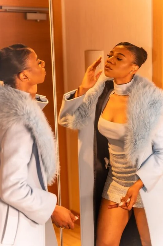 Bogata czarna kobieta w luksusowym pokoju hotelowym sprawdza makijaż