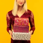 Kobieta w sylwestrowym kapeluszu trzymająca prezenty