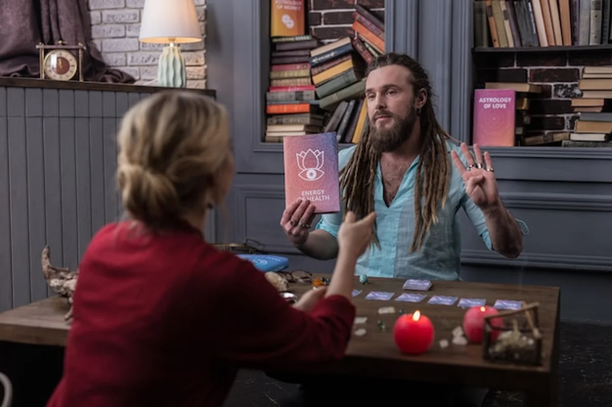 Miły mężczyzna patrzący na klienta podczas rozmowy o książce