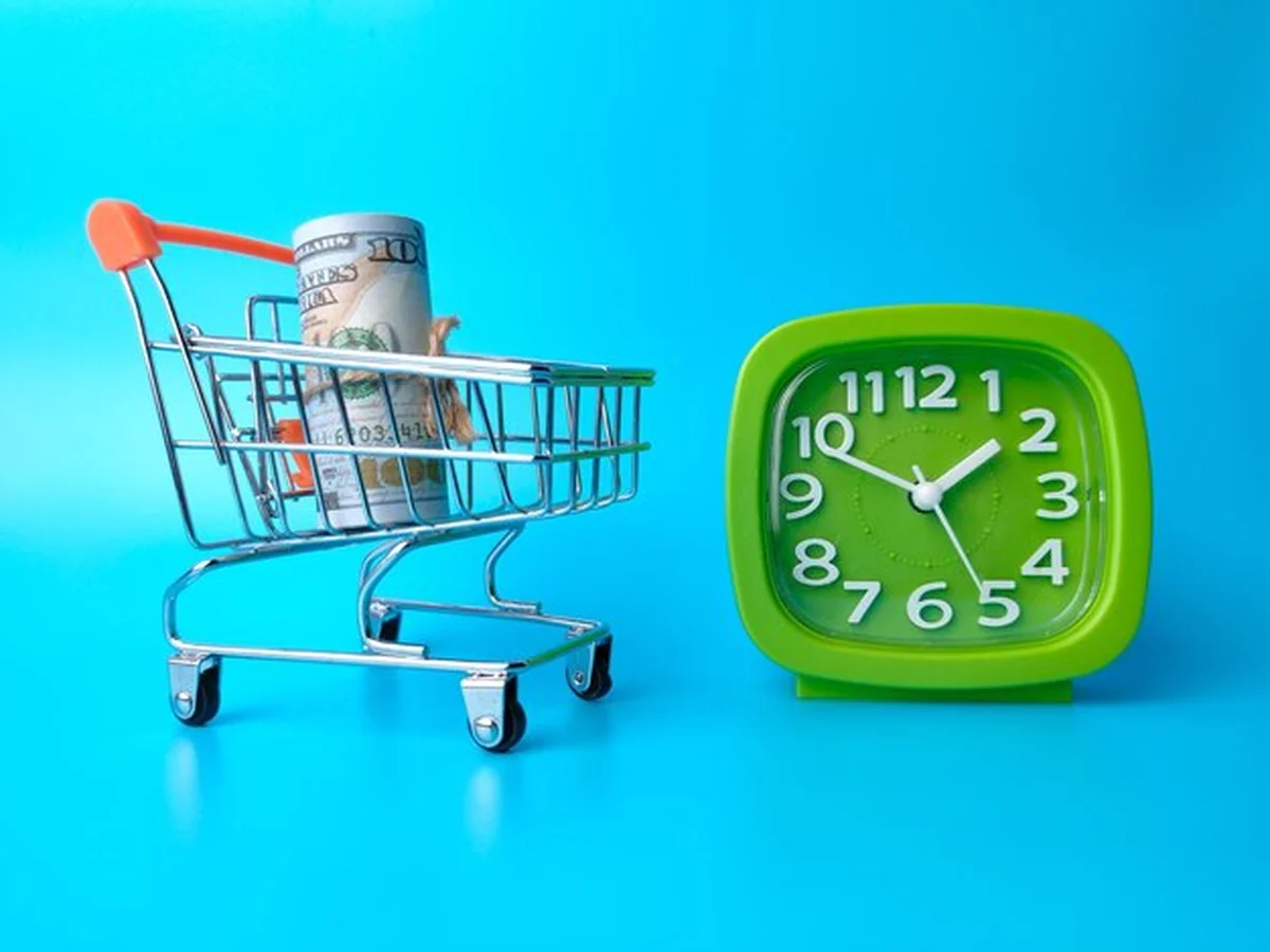 Banknoty z wykresu i budzik na niebieskim tle