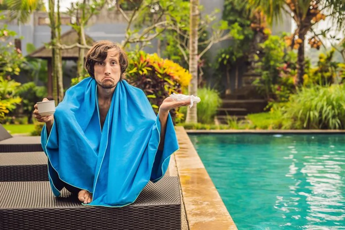 Mężczyzna przeziębiony przy basenie, syn pływa